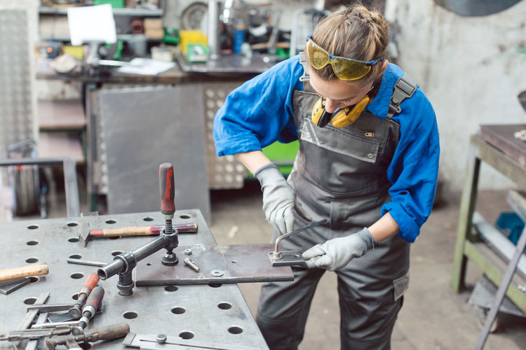 Woman working in metal workshop
