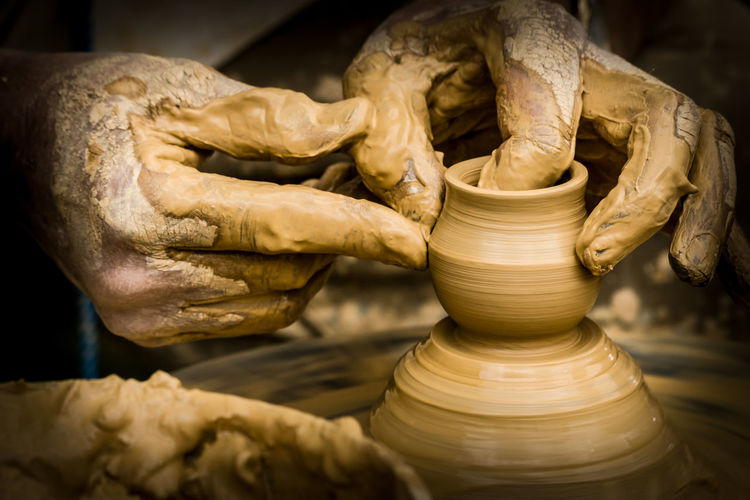 Close-up of hands making pottery