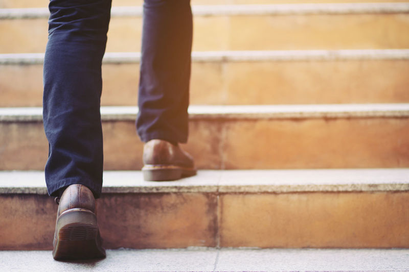 Low section of man standing on staircase