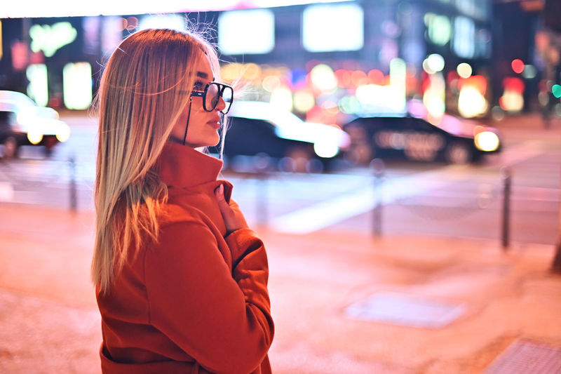 Portrait of young woman looking away in city