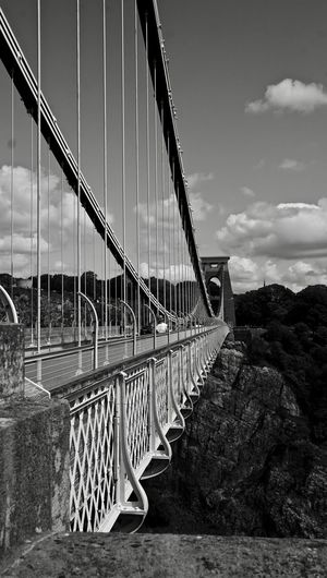 Bridge over river against cloudy sky