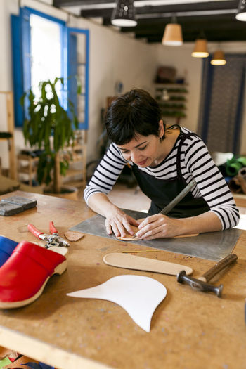 Shoemaker working on template in her workshop