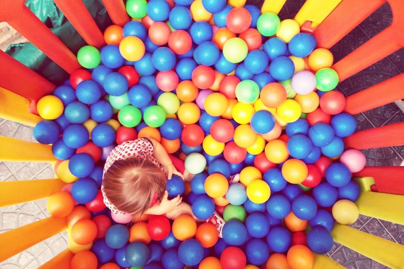 High angle view of baby girl playing in ball pool