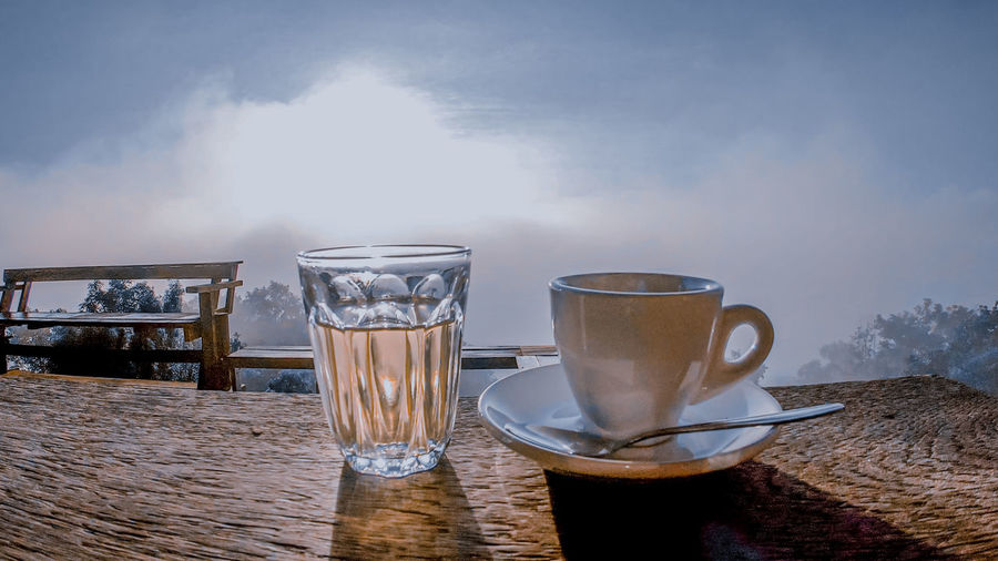 Close-up of coffee cup on table against sky