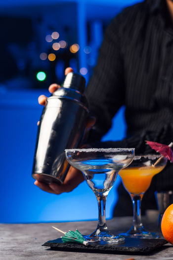 Waiter in a bar is preparing a cocktail