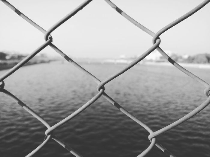 Lake seen through chainlink fence