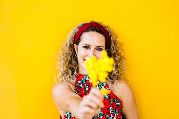 Portrait of a beautiful young woman against yellow background