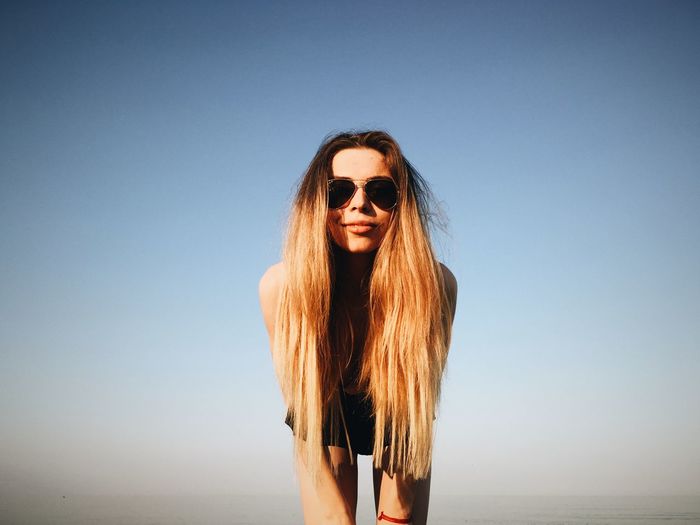 Portrait of woman standing against sky