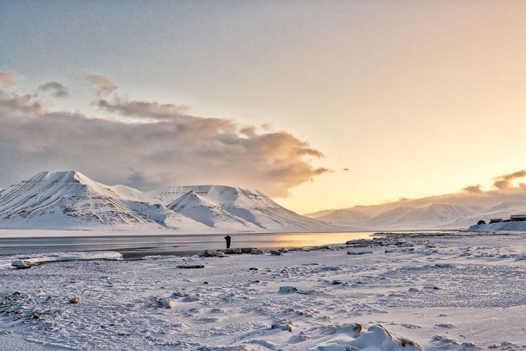 Scenic view of snowcapped mountains against sky during sunset