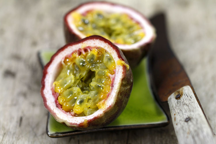 Close-up of sliced passion fruit with table knife on table
