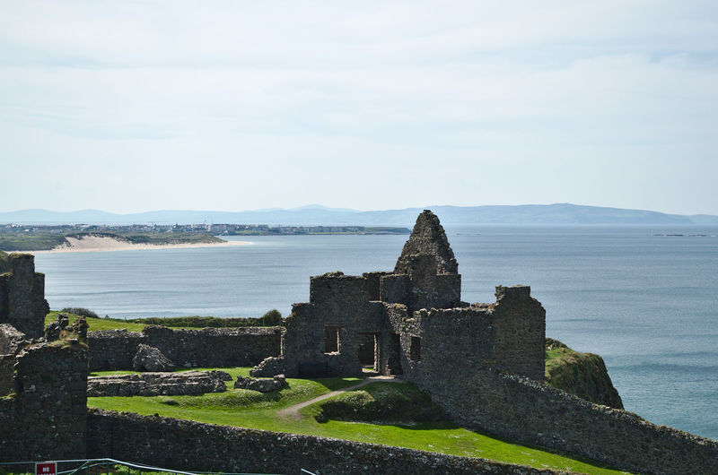 Old building by sea against sky