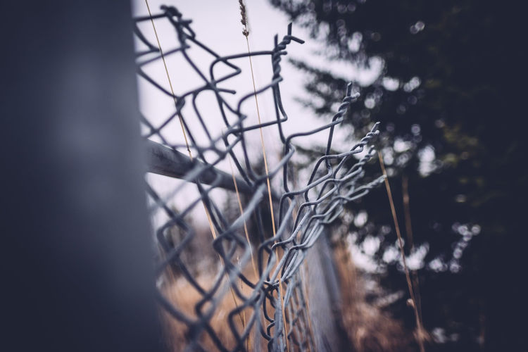 Low angle view of damaged chainlink fence