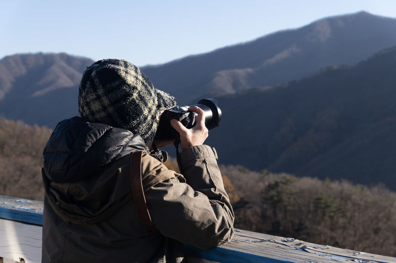 Woman photographing through binoculars