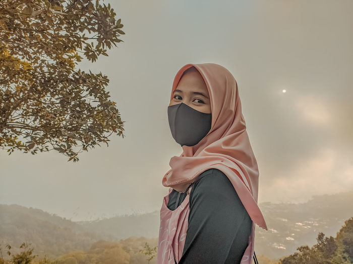 Portrait of woman standing against sky