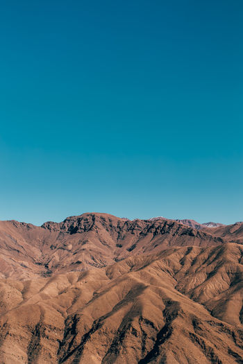 Scenic view of desert against clear blue sky