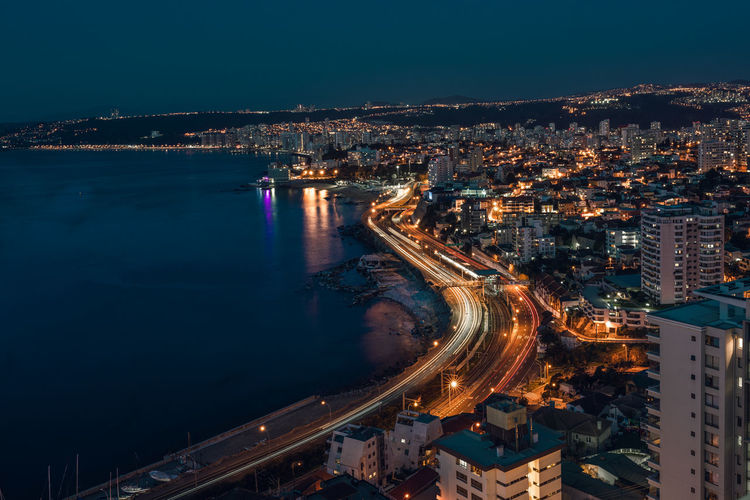 High angle view of illuminated city by river at night