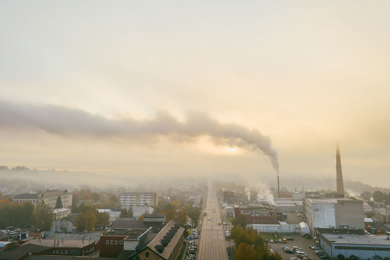 Aerial view of industry emitting smoke against sky