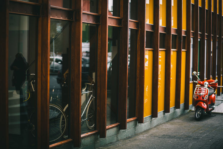Motor scooter parked by wall in city