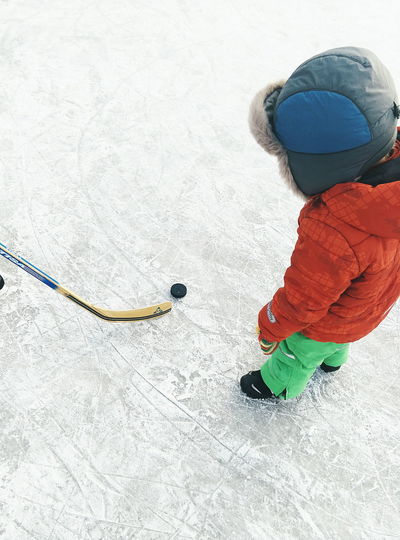 Child with ice hockey equipments on snow