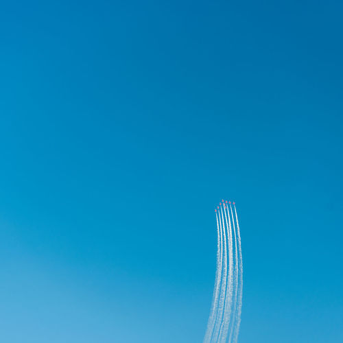 Low angle view of fighter planes flying against clear blue sky