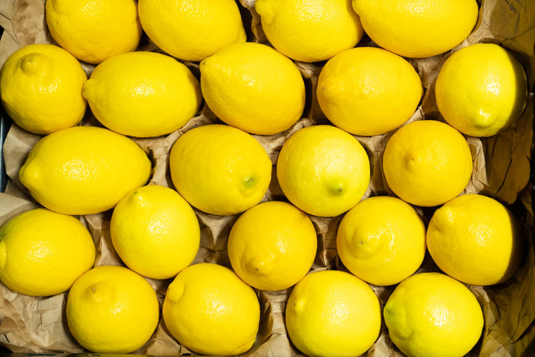 A box or crate with fresh lemons lined in a carton ready for distribution or sale