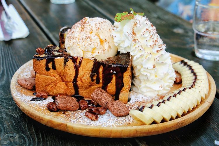 Honey toast dessert with whip cream and banana slices