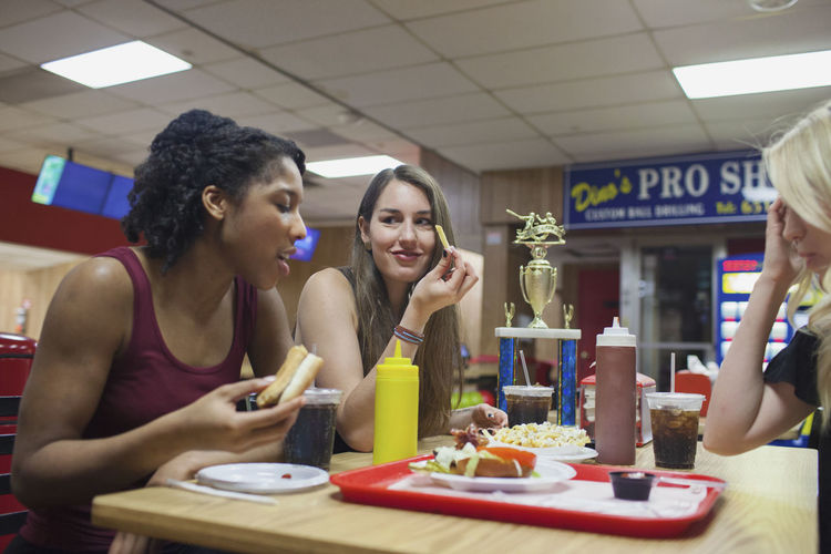 Young women eating at a diner together.
