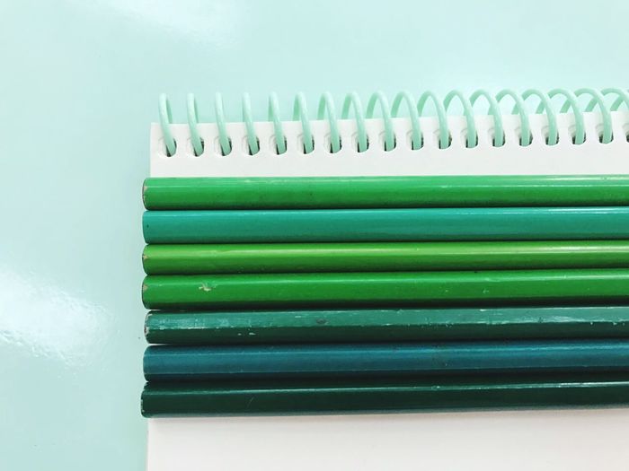 Close-up of pencils on spiral notebook