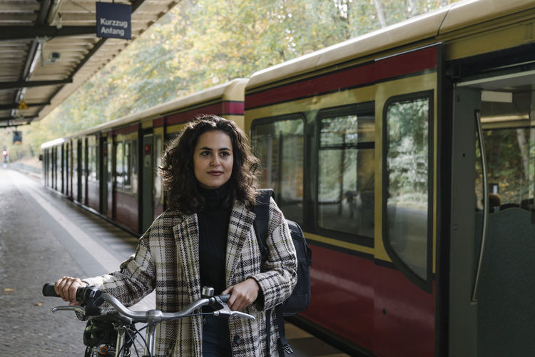 Woman with bicycle on an underground station platform, berlin, germany