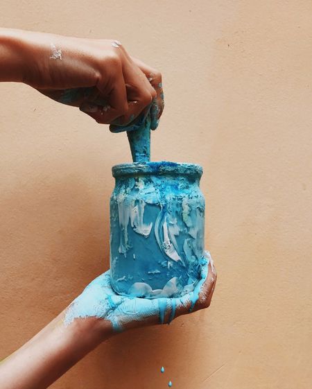 Cropped hand holding paint jar