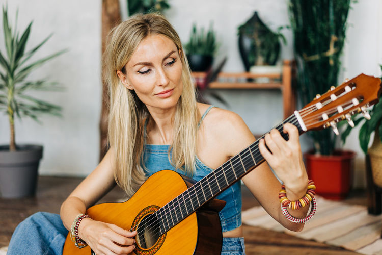 Portrait of romantic woman playing acoustic guitar