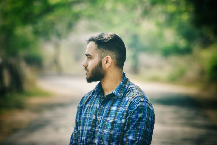 Young man looking away in forest