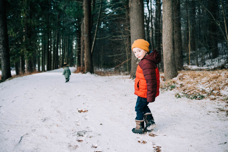 Full length of boy standing on snow covered land