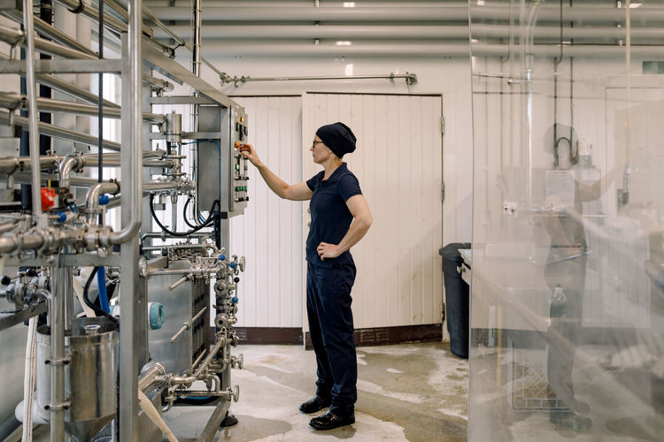 Farmer operating machine at dairy factory