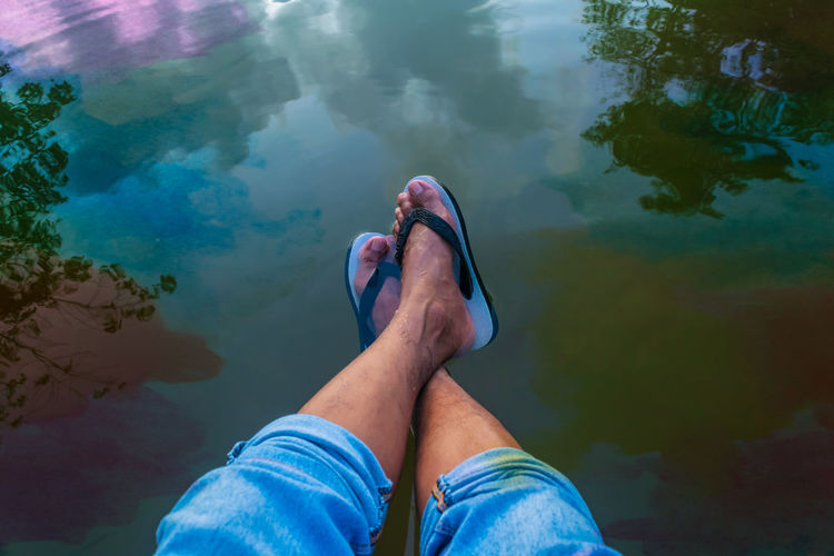 Low section of man relaxing in lake