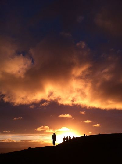 Low angle view of silhouette men against sky during sunset