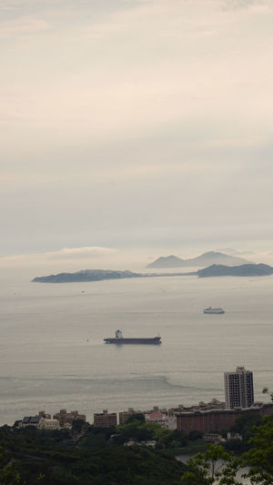 Hong kong cargo ship nuatical transportation  vessel ocean beautiful sunset mountain landscape