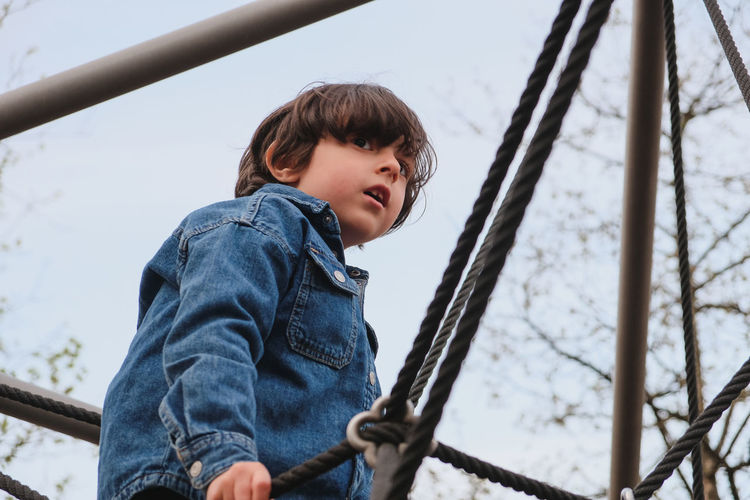 Low angle view of boy standing on slide