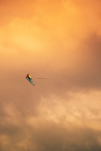 Low angle view of kite against sky during sunset