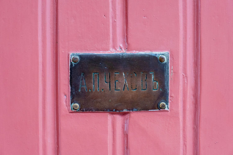 Close-up of mailbox on pink door
