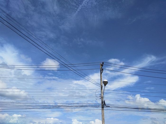 Low angle view of electricity pylon against sky