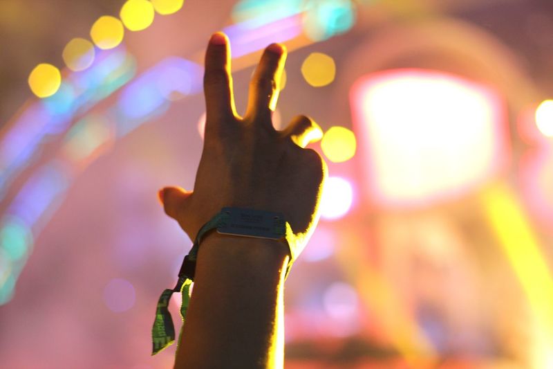 Cropped image of man wearing bracelet at concert 