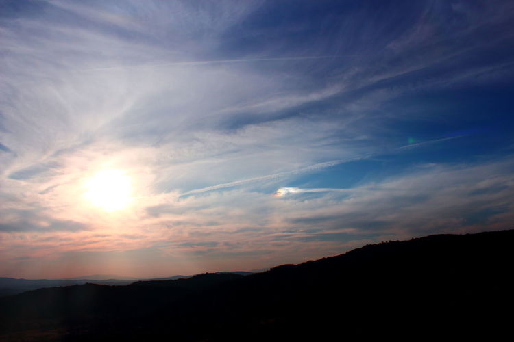 Scenic view of silhouette mountains against sky at sunset