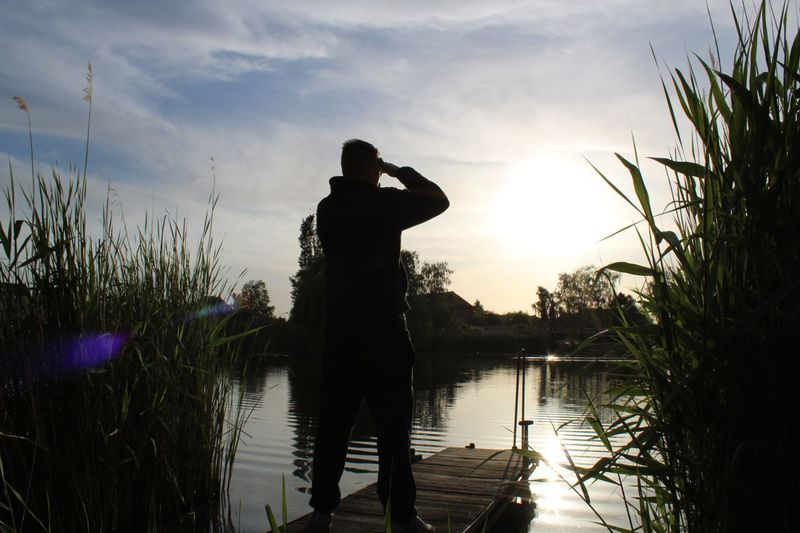 Silhouette of a man looking at the water 