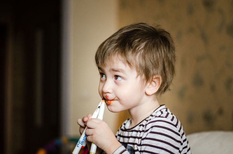 Boy holding markers at home