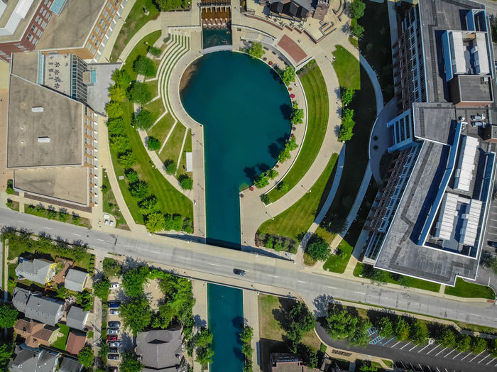 Aerial view of pond in park by buildings at city