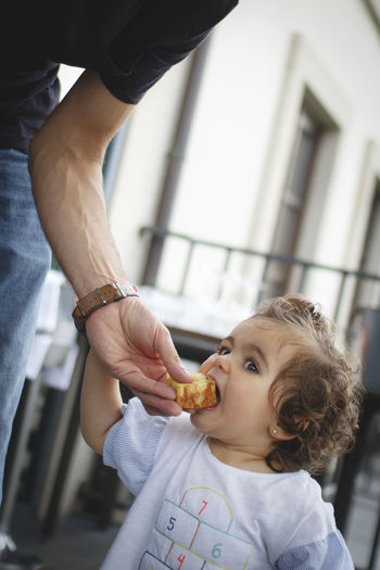 Midsection of father feeding food to daughter