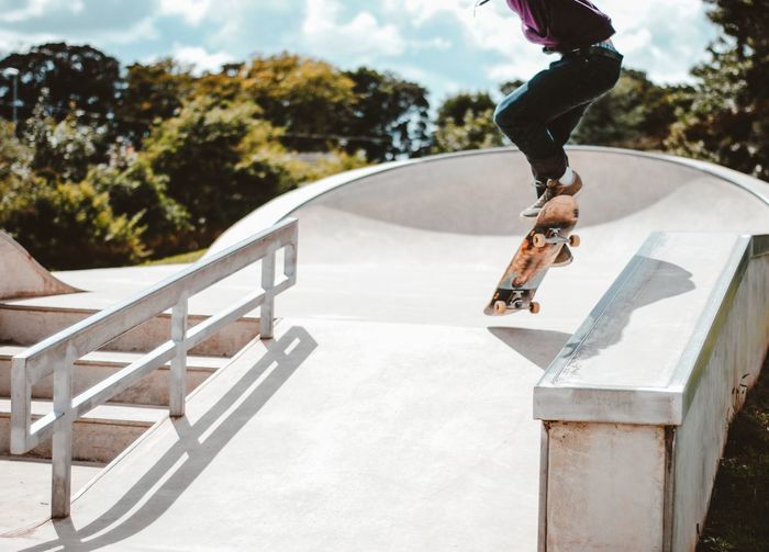Skateboarder jumping in skatepark