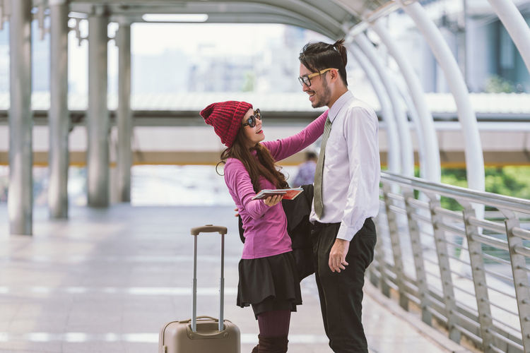 Smiling couple standing on elevated walkway at airport
