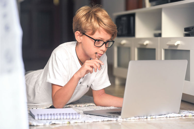 Boy using laptop in living room at home
